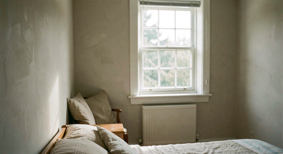 A daylight interior where both the room surfaces and a soft view through the window retain useful tone and spatial information